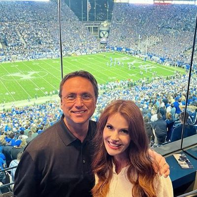 They both are in VIP seats while the crowd can be seen in the background.